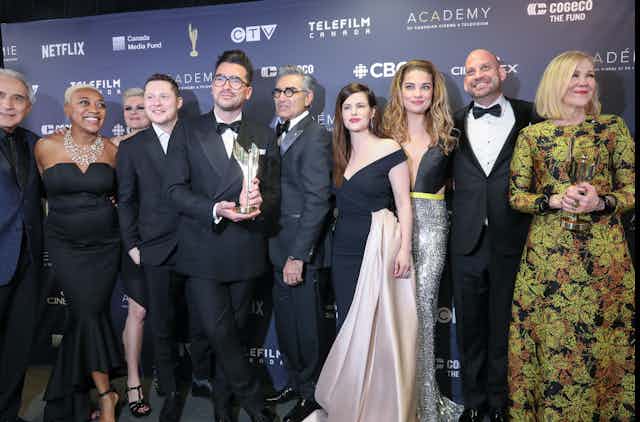 The cast of the sitcom Schitt's Creek posing for a photo at an awards gala.