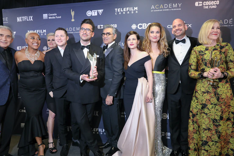 The cast of the sitcom Schitt's Creek posing for a photo at an awards gala.