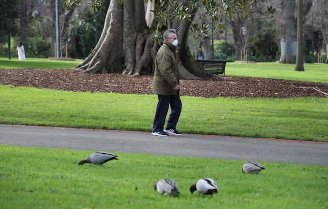 Man wearing face mask walking in park