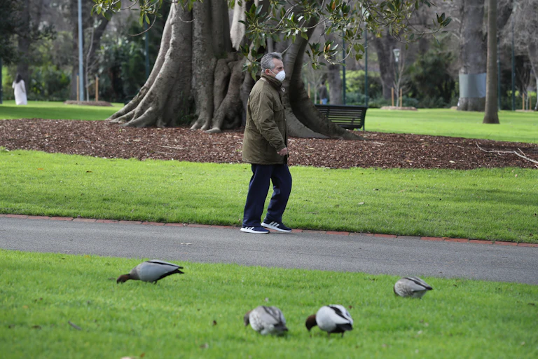 Man wearing face mask walking in park
