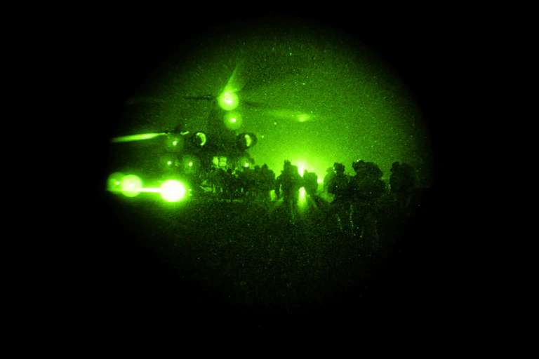 Special operations taskgroup soldiers file into a chinook under cover of darkness