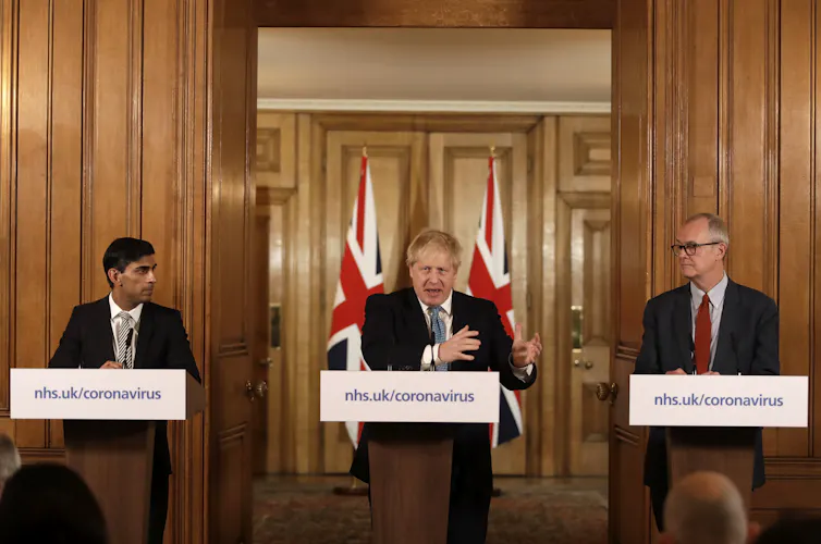 Boris Johnson gives a press briefing on COVID flanked by Rishi Sunak and Patrick Vallance