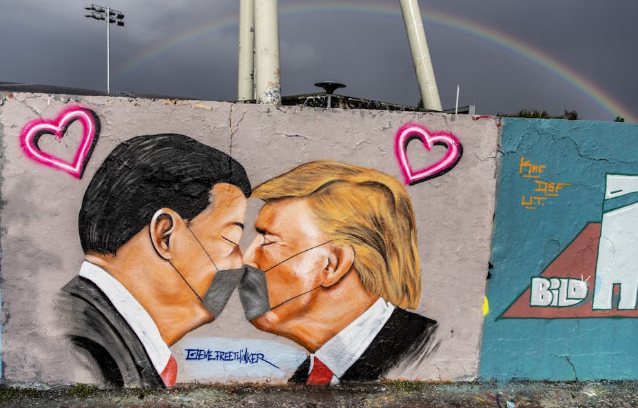 Grafitti artwork showing Xi Jinping and Donald Trump kissing with masks on. 