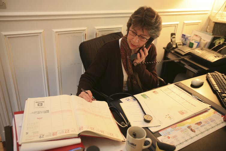 A doctor at her desk on the telephone.