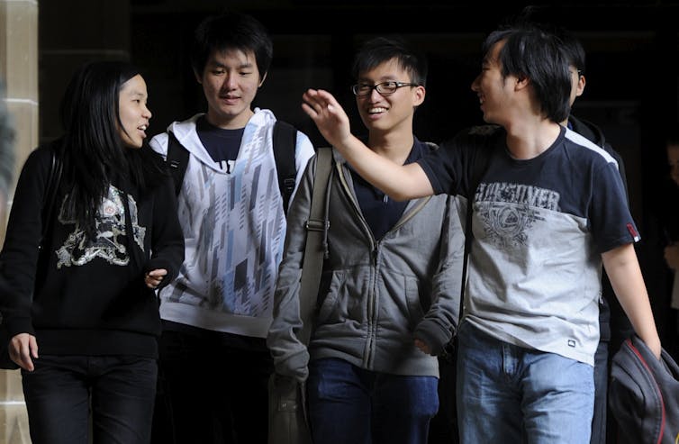 Group of university students smiling and chatting on campus