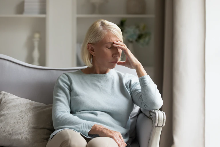 Sad woman sitting on sofa.