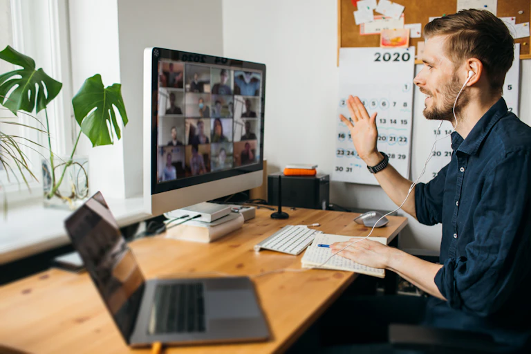 A man at a desk on a video-conference call.