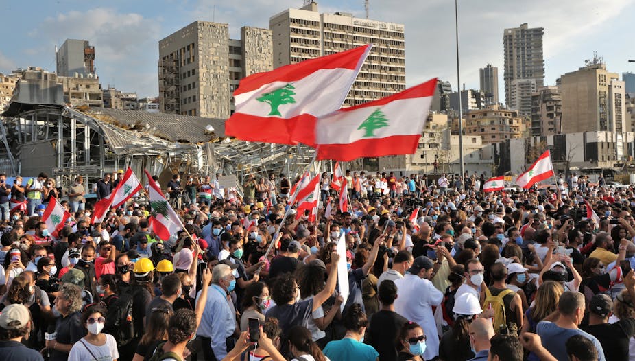 People protesting in Beirut waving Lebanese flag
