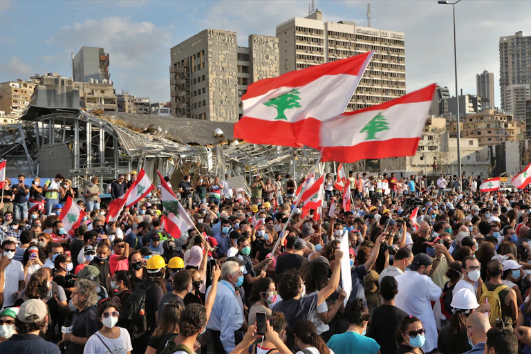 People protesting in Beirut waving Lebanese flag