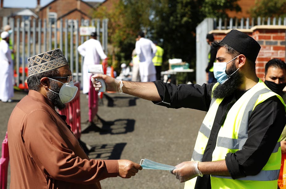 A man has his temperature taken before entering a Mosque in Rochdale, Greater Manchester.