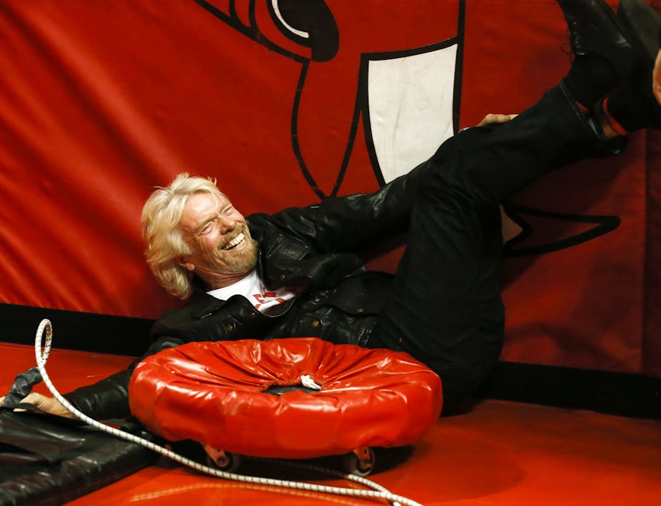Richard Branson laughing behind a rubber ring