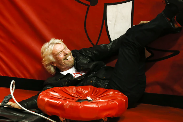 Richard Branson laughing behind a rubber ring