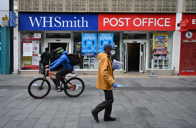 People wear face masks as they shop in Leicester city centre in Leicester, Britain