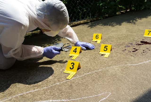 Forensic expert collects evidence at crime scene.