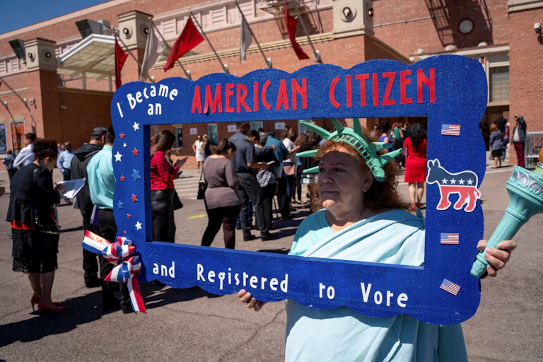 A naturalized citizen dressed as Lady Liberty registering newly sworn in citizens to vote on April 18, 2019 in El Paso, Texas.