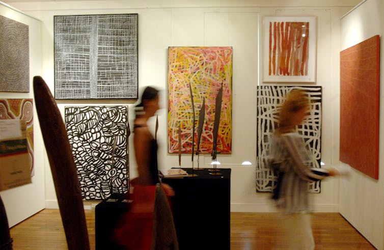 Gallery visitors look at Indigenous art works