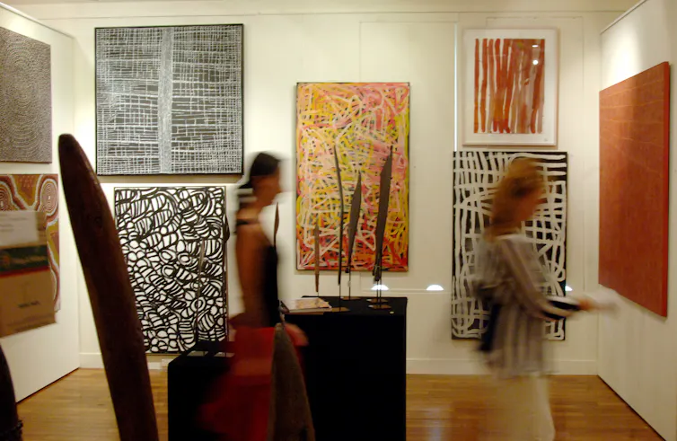 Gallery visitors look at Indigenous art works