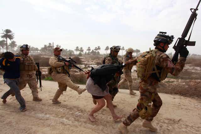 Iraqi security forces arresting suspected Islamic State militants