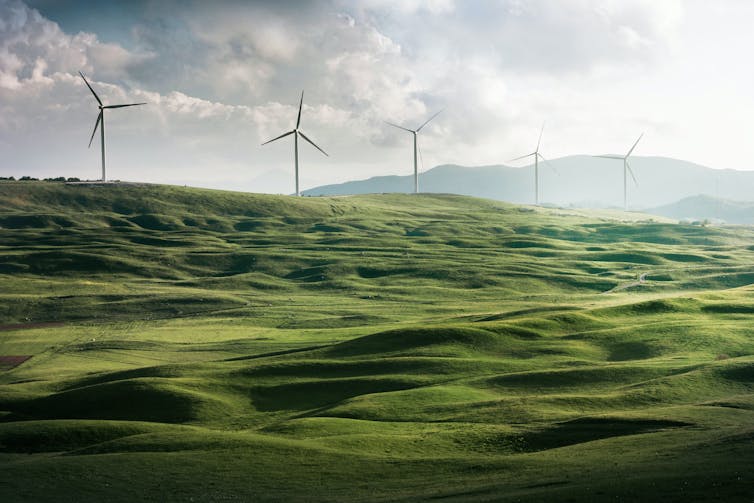 Wind turbines on a green hillside.