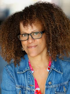 Novelist Bernardine Evaristo wearing a denim jacket and glasses