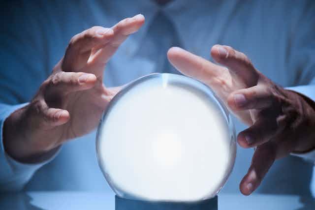 Hands around a glowing crystal ball.