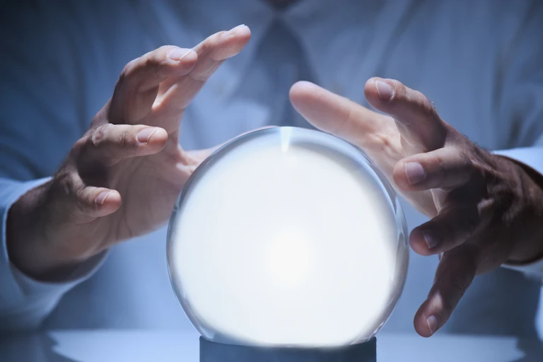 Hands around a glowing crystal ball.