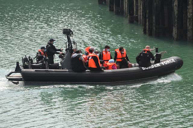 Men arrive in the UK on a border force boat.