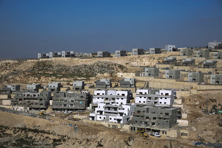 Houses under construction on an arid hilltop in the West Bank