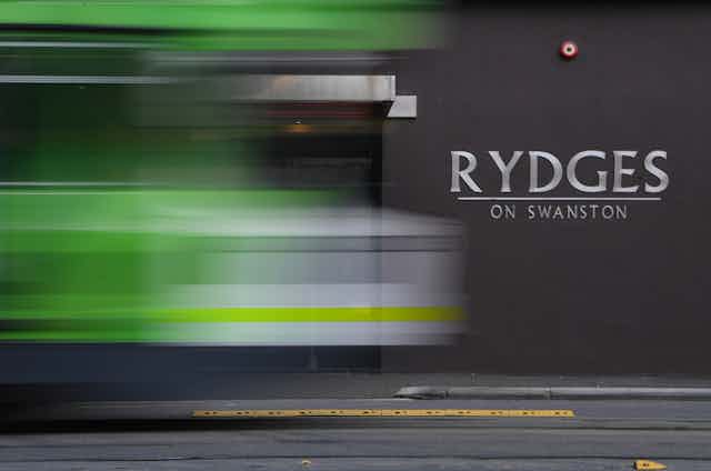 Blurred outline of a tram passing the Rydges hotel.