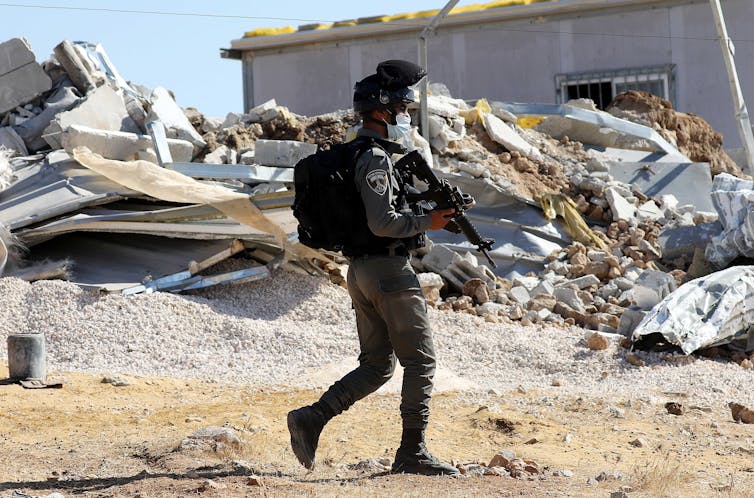 An Israeli border police officer outside a house being demolished in the West Bank.