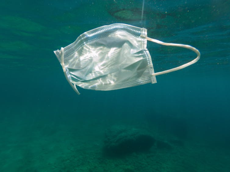 A face mask floating underwater at sea.