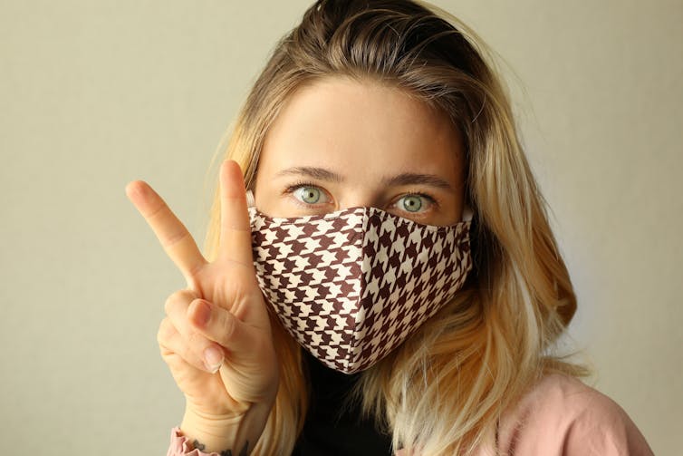 A woman wearing a chequered reusable cloth mask.