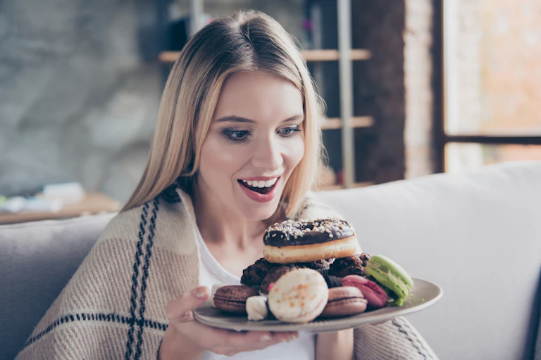 Young woman holding a plate of pastries.