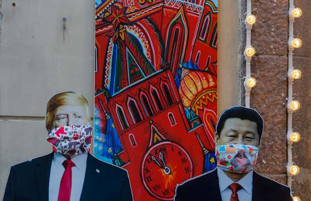 Life-size images of Donald Trump and Xi Jinping with face coverings