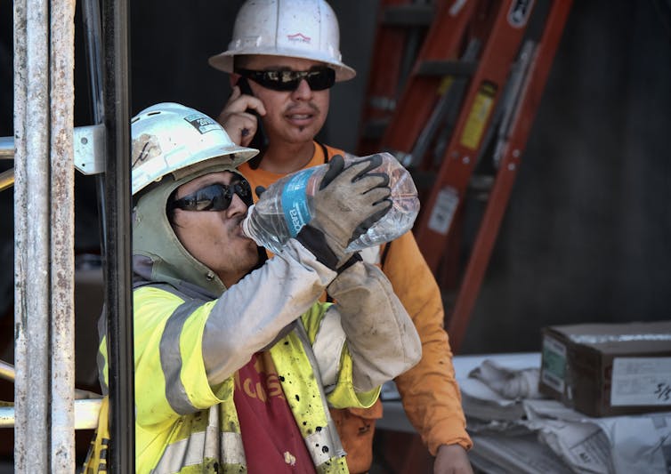 Construction worker drinking water in heat