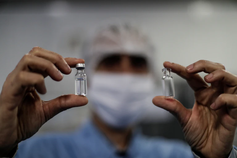 Researcher holding two vials