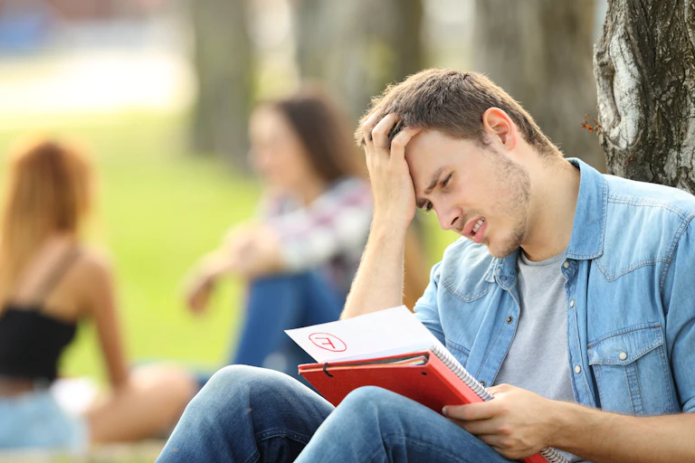 University student stares in dismay at his failed assignment