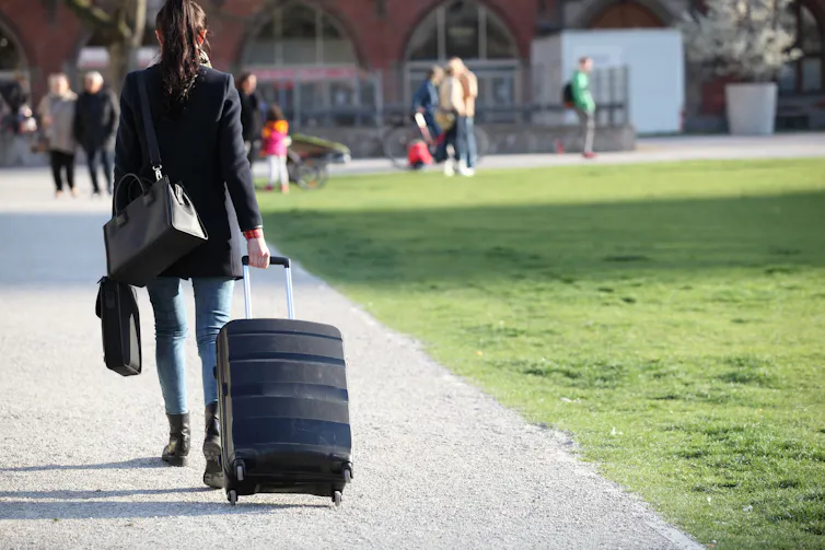 Young woman walking with suitcase