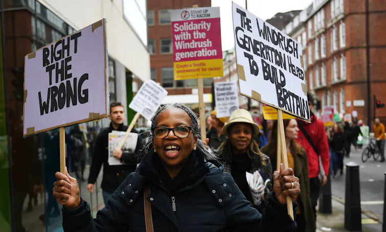 Woman marches in protest holding signs.