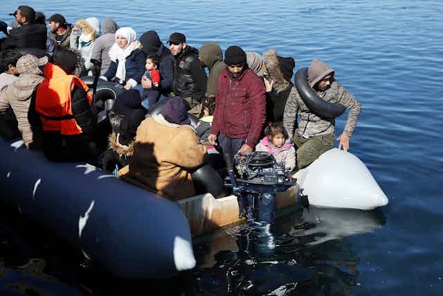 Refugees in an overcrowded dinghy low in the water
