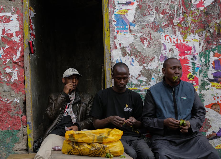 Three men sitting chewing khat leaves