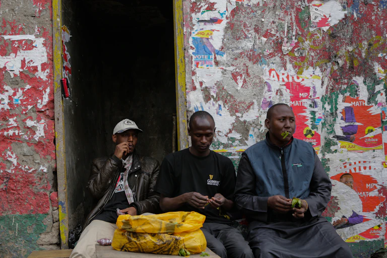 Three men sitting chewing khat leaves