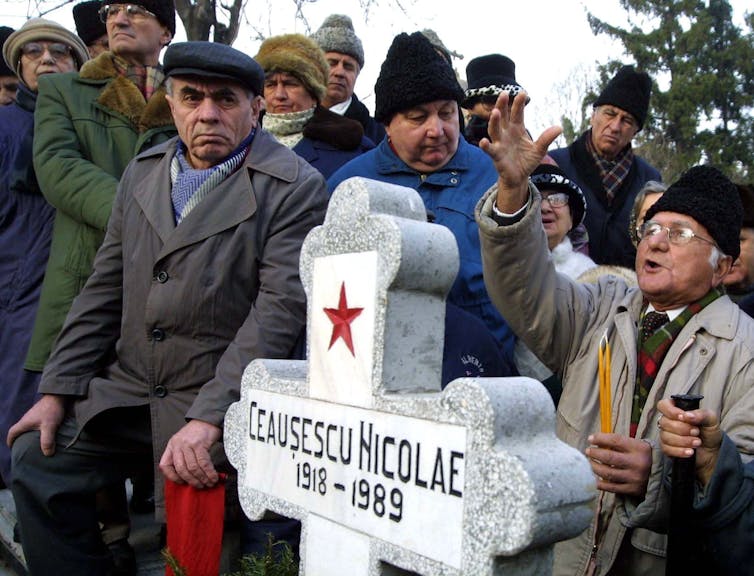 People surround the grave of the late Romanian dictator Nicolae Ceaușescu at Bucharest's Ghencea cemetery.