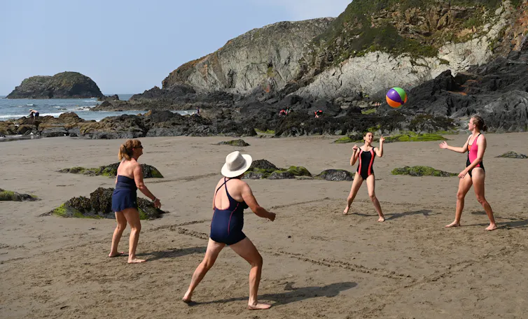 Four women play volleyball on Traeth Llyfn beach in Pembrokeshire, Britain