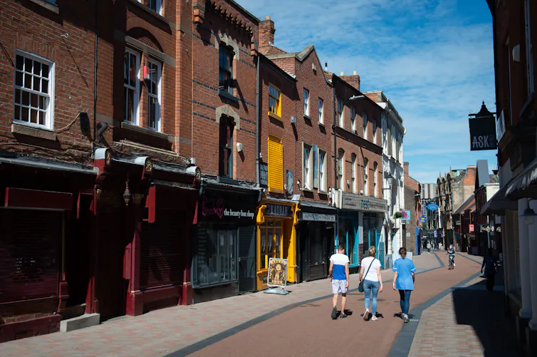 Three people walk down Silver Lane, Leicester.