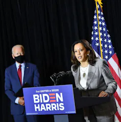 Kamala Harris at podium with Biden in the background