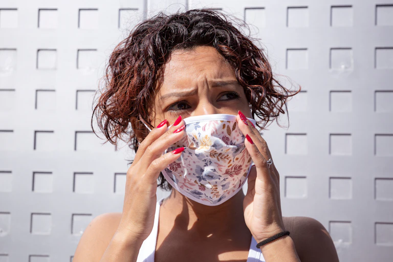 woman wearing face mask looking worried