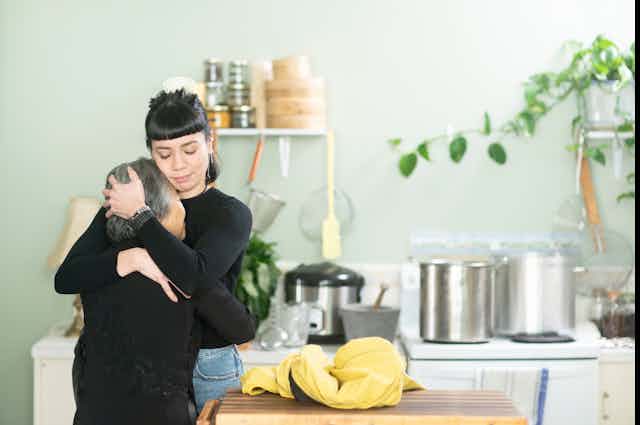 A young Vietnamese woman hugs her grandmother