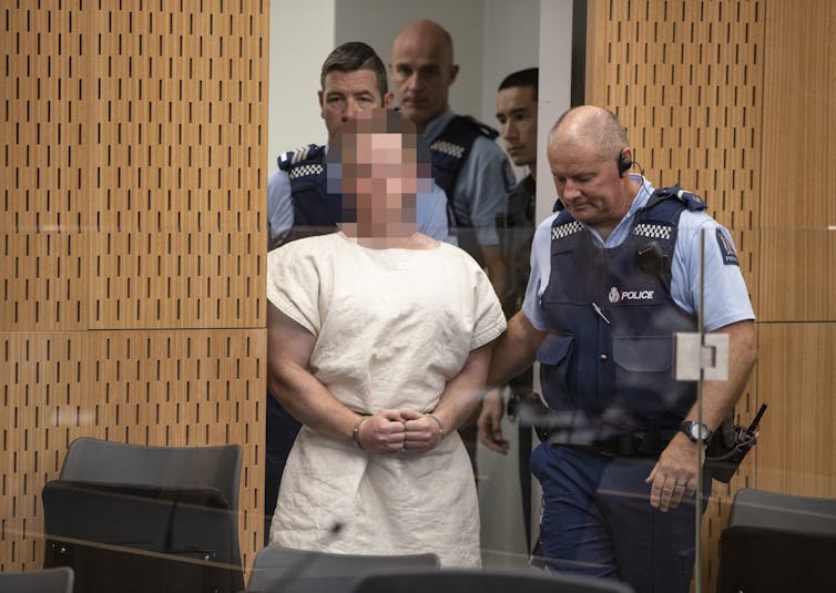 Prisoner and two police officers in courtroom