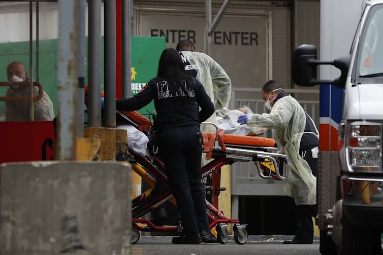 Healthcare workers wheel a patient into a New York hospital on a gurney.